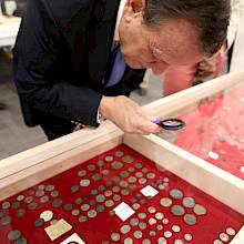 El rector Sánchez observa las colecciones en el Gabinete numismático UC.  Foto Karina Fuenzalida